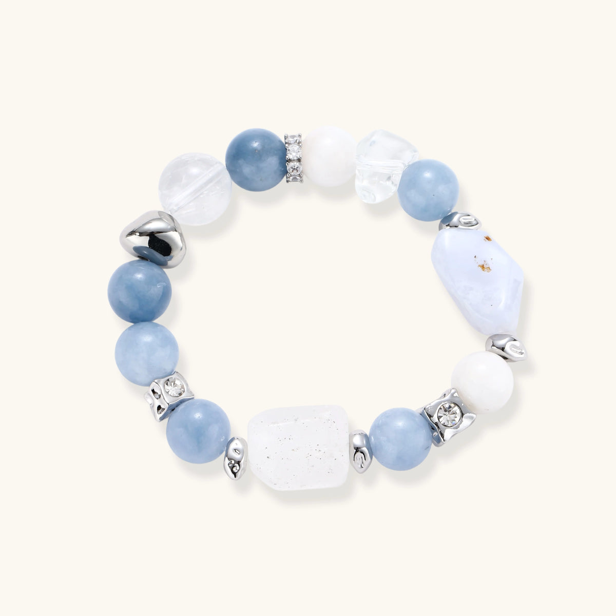 Stretchable bracelet with blue aquamarine beads, clear quartz crystals and copper accents on white background.