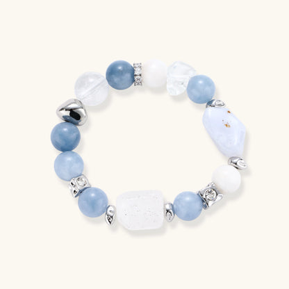 Stretchable bracelet with blue aquamarine beads, clear quartz crystals and copper accents on white background.